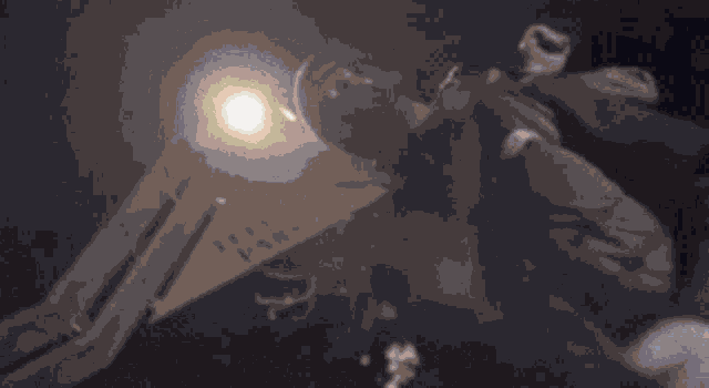 a man is laying on the ground in a dark room with a light shining on him .