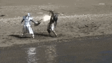 a black and white photo of two people standing on a beach .
