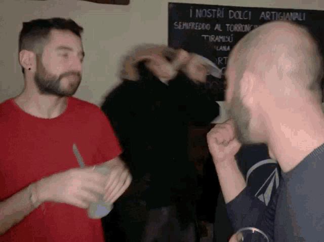 two men are standing in front of a blackboard that says i nostri dolci artigianali