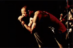 a man singing into a microphone on a stage