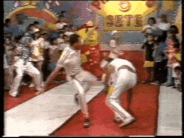 a group of people are dancing on a red carpet in front of a sign that says sete