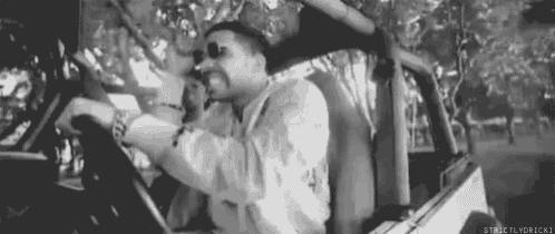 a black and white photo of a man driving a jeep .