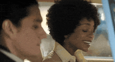 a man and a woman are sitting in a car with the woman smiling