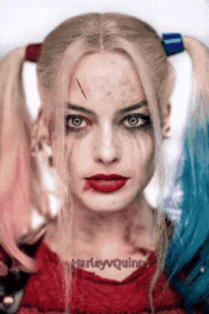a close up of a woman in a harley quinn costume with pigtails .