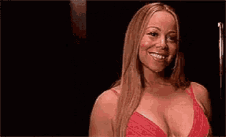 a woman in a red bra is smiling in a dark room .
