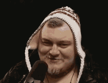 a man with a beard wearing a knitted hat and a microphone