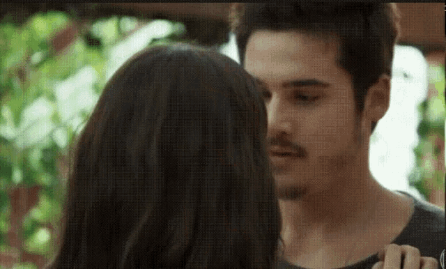 a man and a woman are kissing and hugging each other .