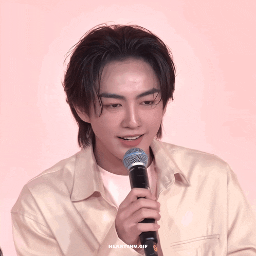 a close up of a person holding a microphone with the words heartchulife written on the bottom