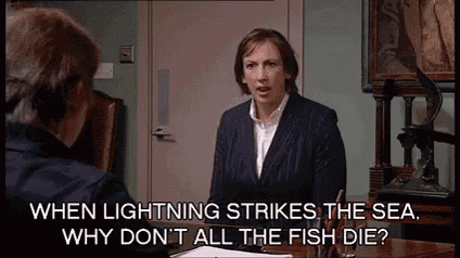 a woman is sitting at a desk talking to another woman while a lightning strikes the sea .