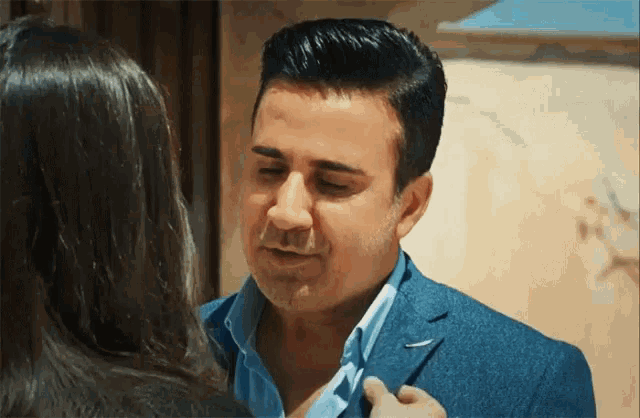 a man in a suit is talking to a woman in a black jacket