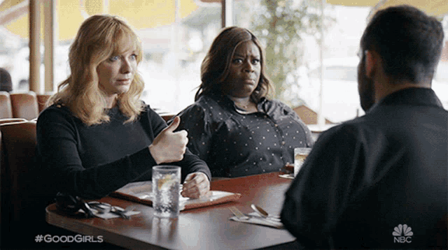 two women sit at a table with a man in a nbc advertisement for good girls