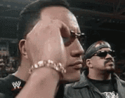 a man wearing sunglasses and a bracelet with a w on it