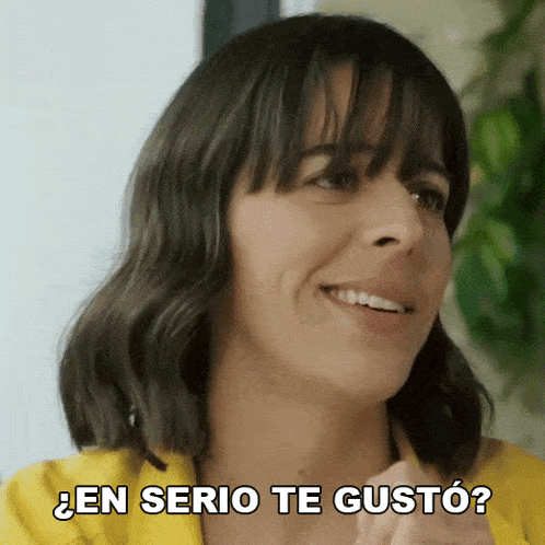 a woman in a yellow shirt is smiling and says en serio te gusto