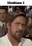 a man with a beard is making a funny face while sitting in a crowd .