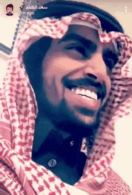 a close up of a man wearing a head scarf and a hat