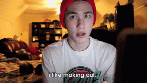 a young man wearing a red beanie and a white shirt says i like making out