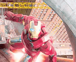 a man in an iron man suit is flying through the air .