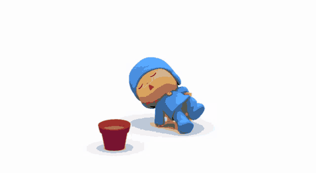 a cartoon character laying on the ground next to a red bucket