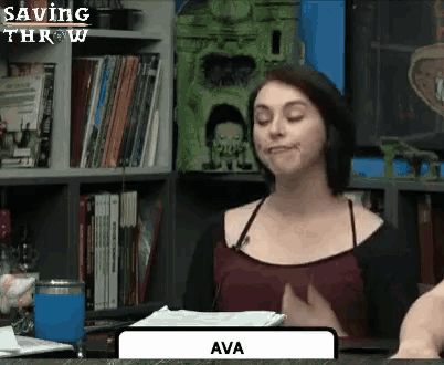 a woman is sitting at a table in front of a bookshelf in a library .