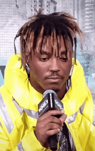 a man in a yellow jacket is holding a microphone that says 106.1 on it