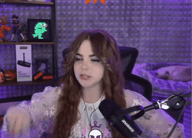 a girl is sitting in front of a shure microphone .