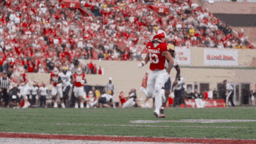 a football player wearing a red uniform with the number 13 on it
