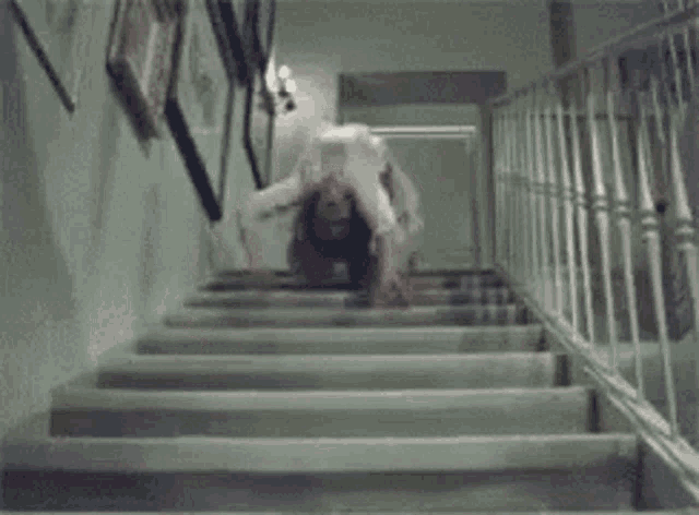 a woman is crawling up a set of stairs .