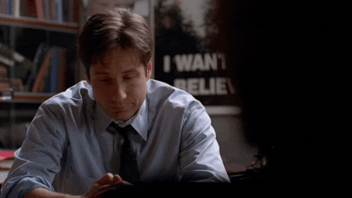 a man is sitting in front of a sign that says " i want n't believe "
