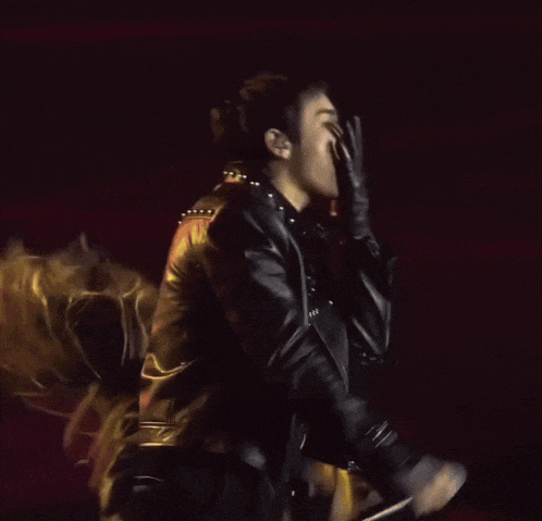 a man in a leather jacket is licking his lips