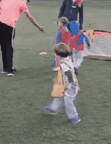 a group of children are playing on a grassy field
