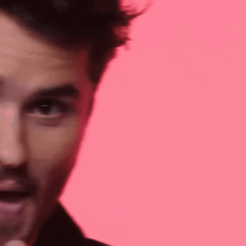 a close up of a man 's face against a pink background .