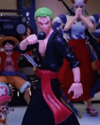 a toy figure of a man with green hair is holding a sword