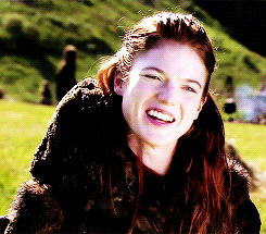 a woman in a fur coat is smiling and looking at the camera