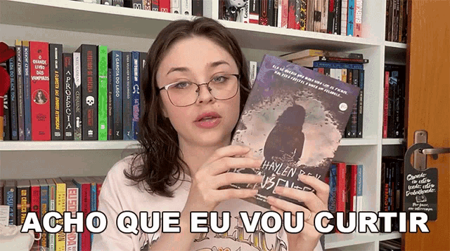 a woman holding a book with the words acho que eu vou curtir written below her