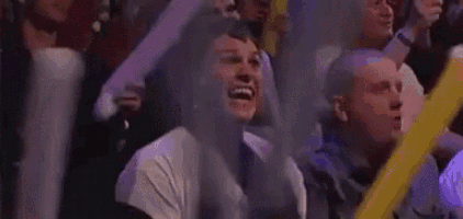a man is screaming in a crowd of people while wearing a white shirt with the word elevation on it .