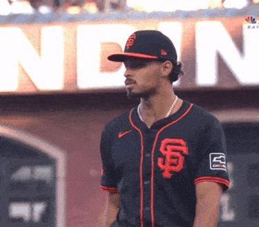 a man wearing a sf jersey stands in front of a sign that says nbc