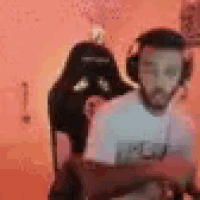 a man wearing headphones is sitting in a chair in front of a computer screen .