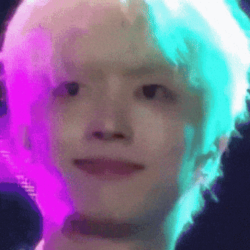 a close up of a person 's face with a purple and green background
