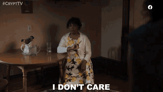 a woman sitting at a table with the words i don 't care below her