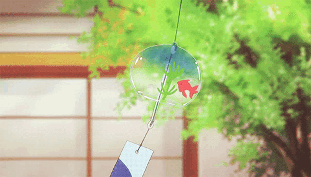 a wind chime with a fish in it is hanging from a string