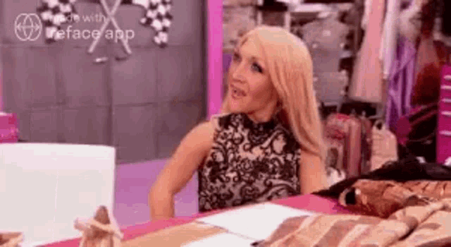 a woman in a black dress is sitting at a table with a laptop .