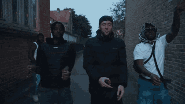 a group of men are walking down a sidewalk .