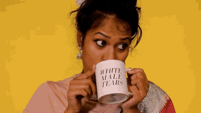 a woman is drinking from a white mug that says white male tears