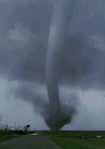 a large tornado is coming down a road