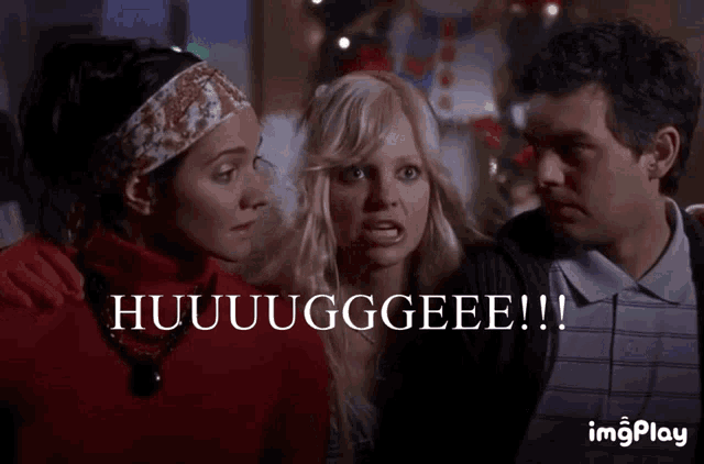 a man and two women are standing next to each other with the words huuuugggeee written on the bottom