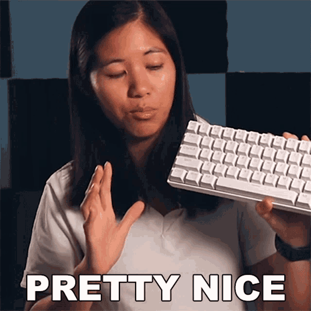 a woman is holding a keyboard and says " pretty nice " in white letters