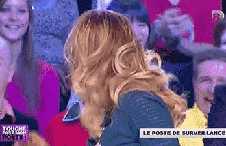 a woman is standing in front of a crowd with a sign that says le poste de surveillance on it