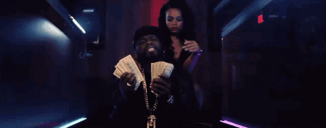 a man is holding a fan of money in front of a woman who is holding a gun