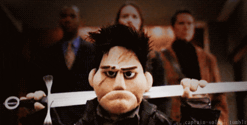 a puppet is holding a sword in front of a group of people and the words captain-solg tumblr are on the bottom right