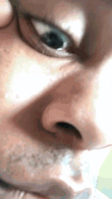 a close up of a man 's face with a beard and blue eyes